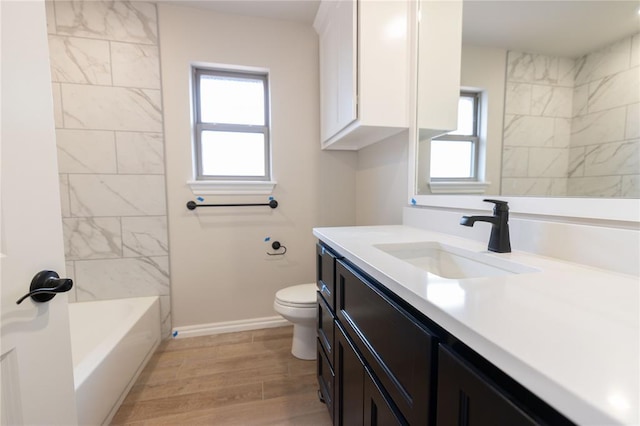 full bathroom with toilet, vanity, wood-type flooring, and a wealth of natural light