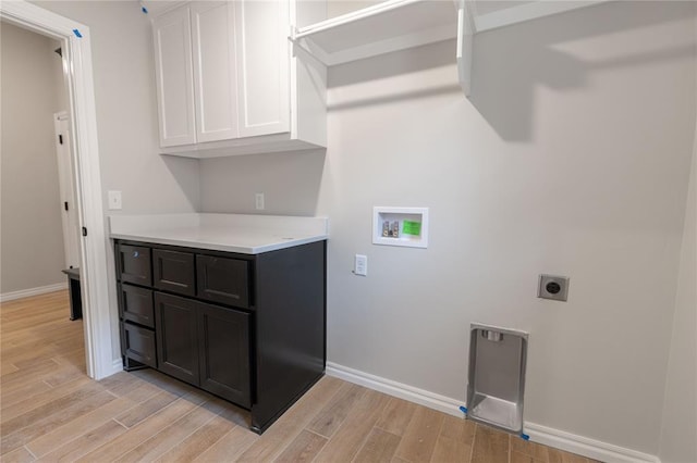 clothes washing area with washer hookup, hookup for an electric dryer, and cabinets