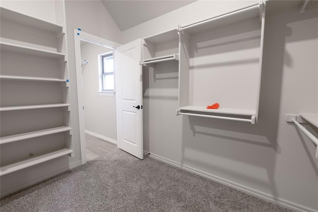 spacious closet with lofted ceiling and carpet