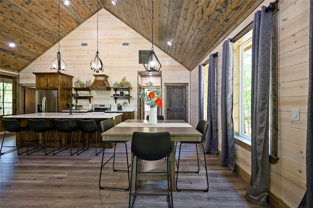 dining room featuring wooden ceiling, plenty of natural light, and wooden walls