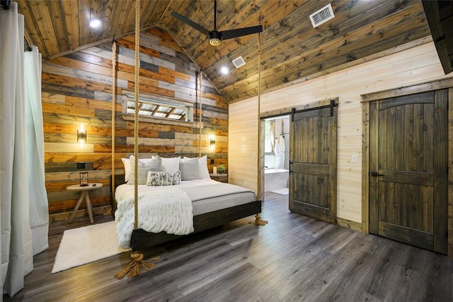 bedroom with wooden ceiling, high vaulted ceiling, wooden walls, a barn door, and dark hardwood / wood-style flooring