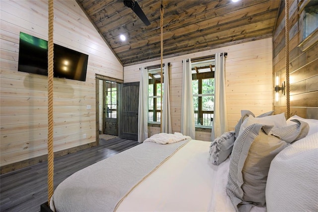 bedroom featuring multiple windows, wood walls, and dark wood-type flooring