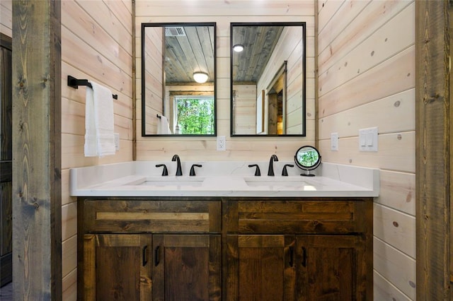 bathroom featuring vanity and wood walls