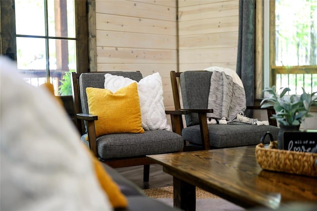 living area with wood walls and hardwood / wood-style flooring