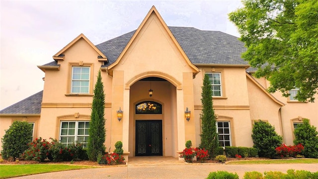 view of exterior entry with stucco siding and french doors
