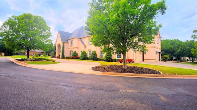 view of front of house featuring a garage, stucco siding, and driveway