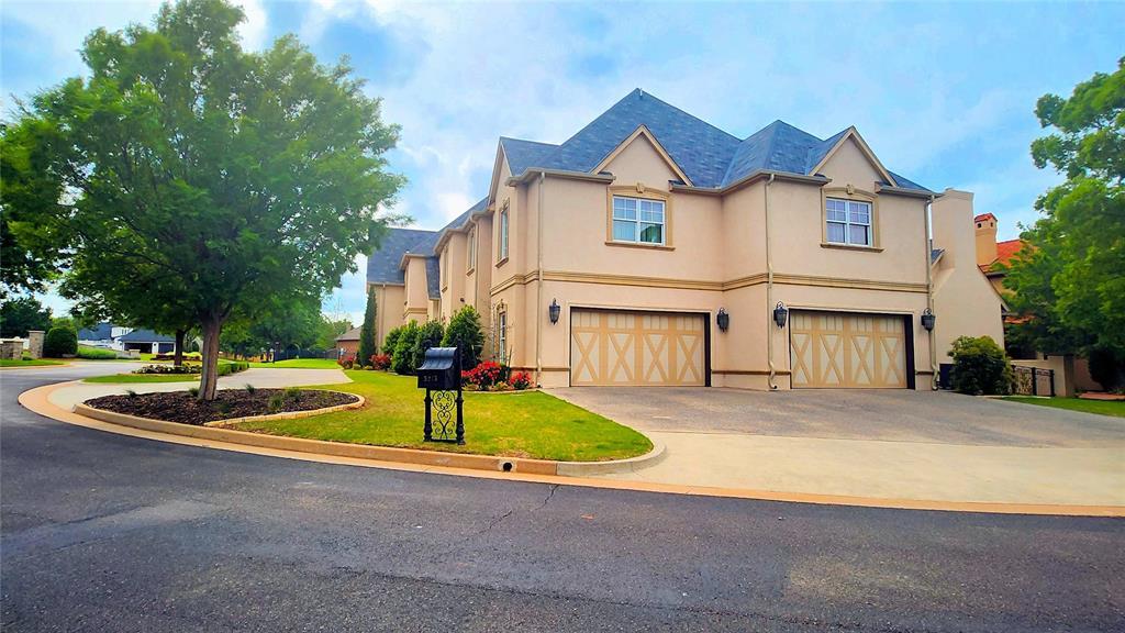 view of front of property featuring stucco siding, concrete driveway, a front lawn, and a garage