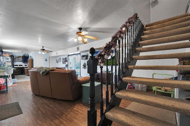 living room with ceiling fan, hardwood / wood-style floors, and a textured ceiling