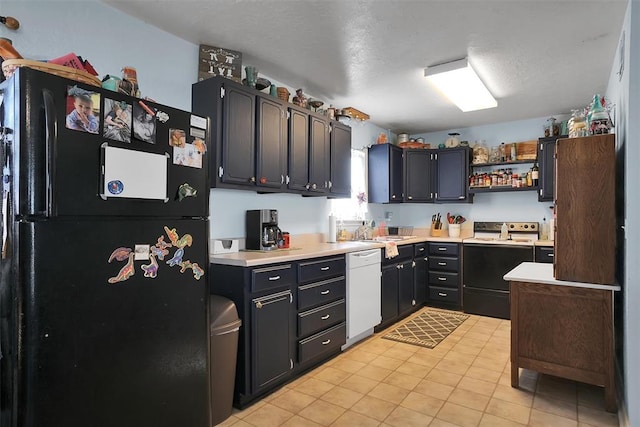 kitchen featuring black refrigerator, electric range oven, sink, light tile patterned floors, and dishwasher