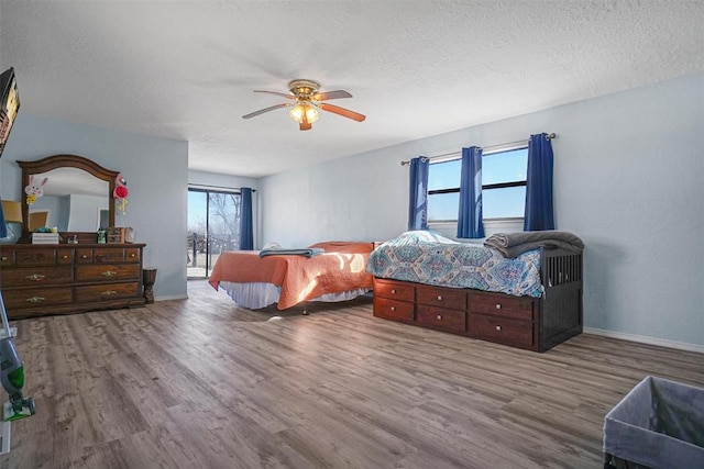 bedroom with multiple windows, ceiling fan, and hardwood / wood-style floors