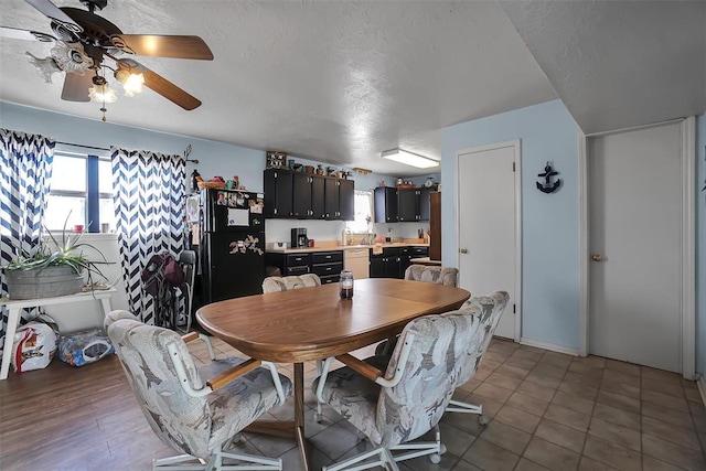 dining space featuring ceiling fan, light tile patterned floors, and a textured ceiling