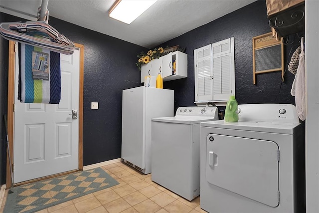 laundry area featuring light tile patterned floors, cabinets, and independent washer and dryer