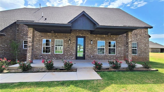 200 Braxton Way, Yukon, OK 73099 - view of front of property with brick siding, a front yard, a patio, and a shingled roof