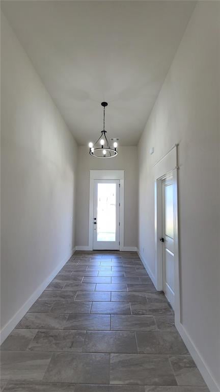 doorway to outside featuring a notable chandelier