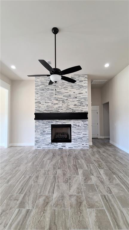 unfurnished living room featuring a fireplace and ceiling fan