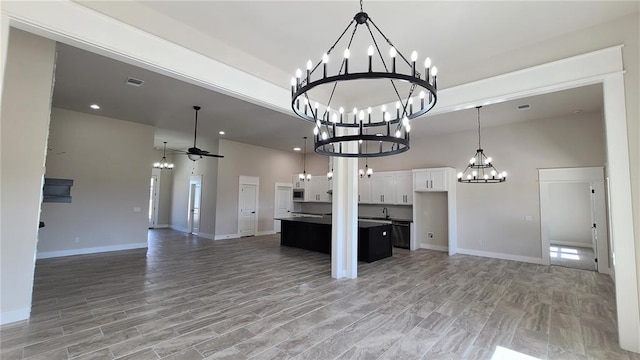 kitchen with white cabinetry, hardwood / wood-style floors, ceiling fan, and a kitchen island with sink