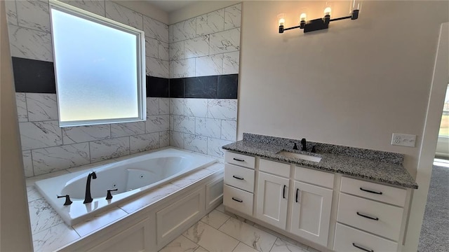 bathroom featuring vanity and tiled tub