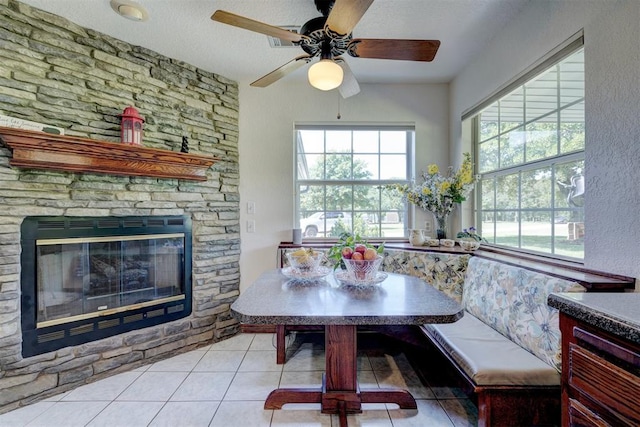 tiled dining area featuring a fireplace, breakfast area, and a textured ceiling