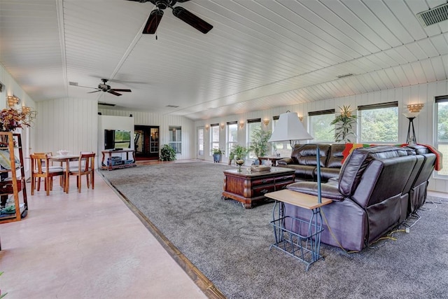 living room featuring ceiling fan, concrete flooring, and lofted ceiling