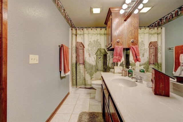 bathroom featuring tile patterned floors, vanity, a textured ceiling, and toilet