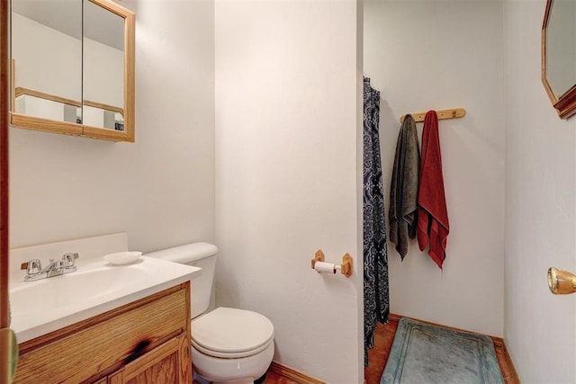 bathroom with hardwood / wood-style floors, vanity, and toilet