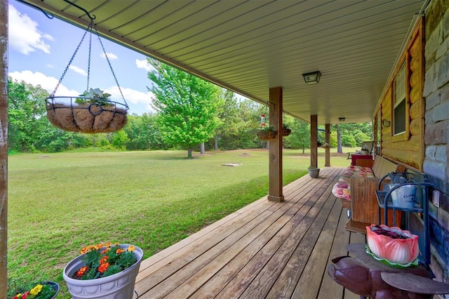 wooden deck featuring covered porch and a yard