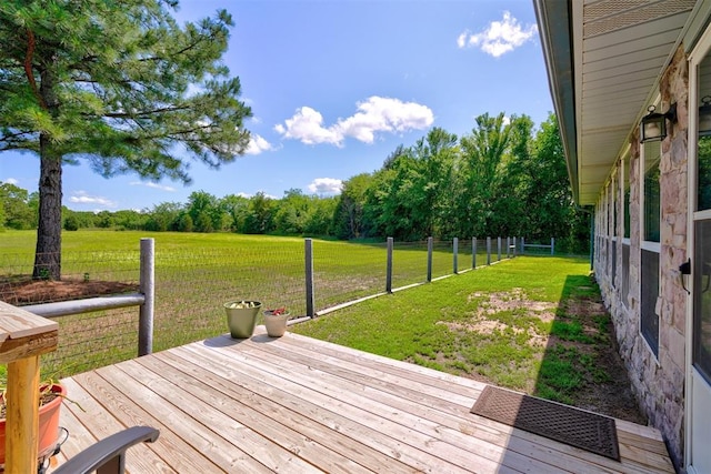 wooden terrace with a rural view and a yard