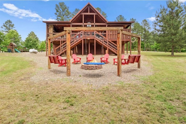 view of jungle gym with a fire pit, a yard, and a wooden deck