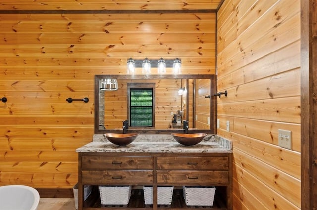 bathroom featuring a bathtub, vanity, and wood walls