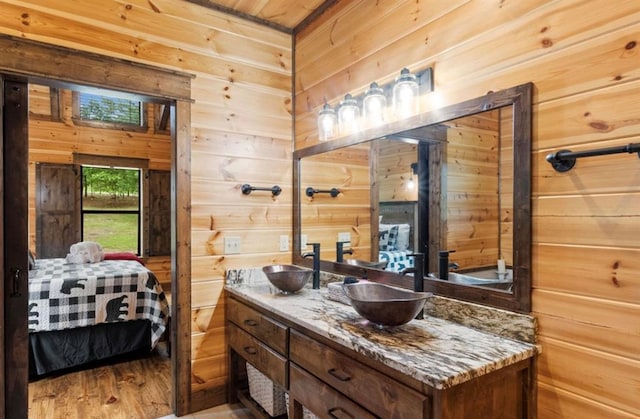 bathroom with hardwood / wood-style floors, vanity, and wood walls