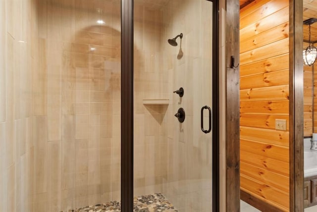 bathroom with an enclosed shower and wooden walls