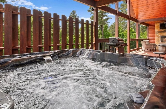 view of patio with area for grilling and a hot tub