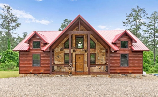 view of front of house with crawl space, metal roof, covered porch, and stone siding