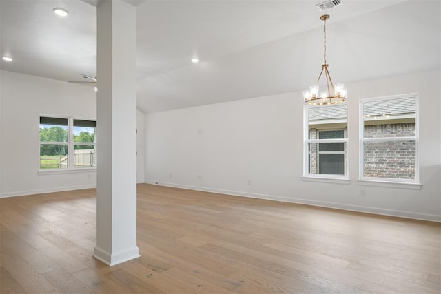 unfurnished room featuring ceiling fan with notable chandelier, light hardwood / wood-style floors, and lofted ceiling