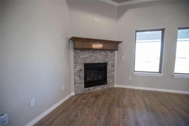 unfurnished living room featuring a stone fireplace, dark hardwood / wood-style flooring, and a healthy amount of sunlight