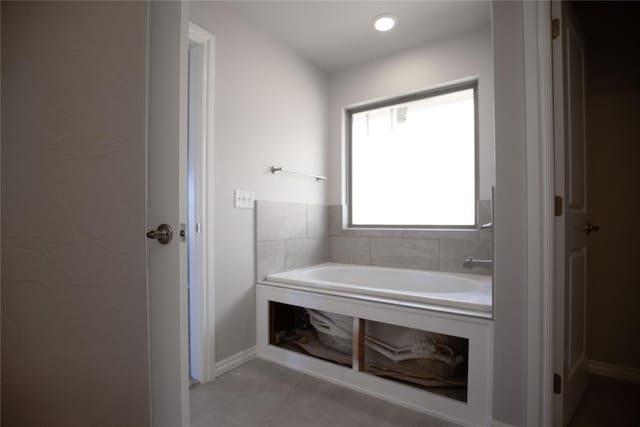 bathroom with tile patterned flooring and a tub to relax in