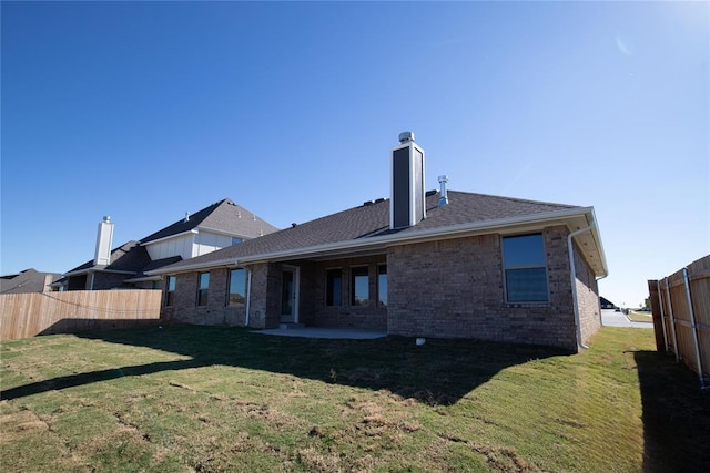 back of property with a lawn and a patio