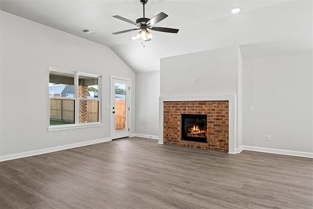 unfurnished living room featuring dark hardwood / wood-style floors, ceiling fan, lofted ceiling, and a brick fireplace