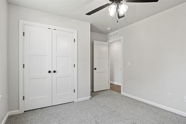 unfurnished bedroom with ceiling fan, carpet floors, and a closet