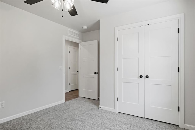 unfurnished bedroom featuring carpet floors, a closet, and ceiling fan