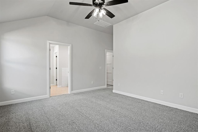 spare room with carpet flooring, vaulted ceiling, and ceiling fan