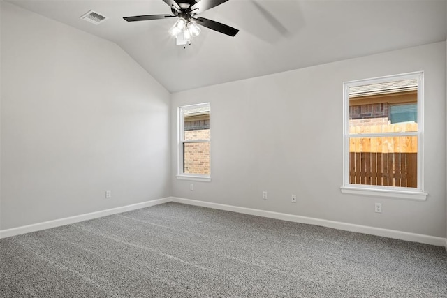 empty room with carpet flooring, a wealth of natural light, lofted ceiling, and ceiling fan