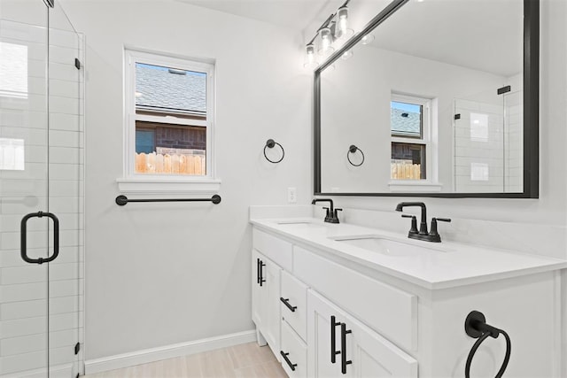 bathroom with hardwood / wood-style flooring, vanity, a healthy amount of sunlight, and a shower with door