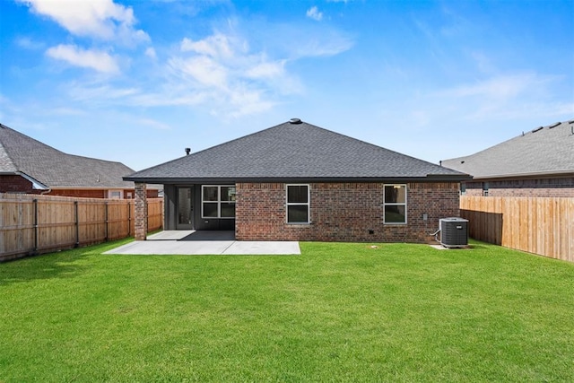 rear view of property with a lawn, a patio area, and central air condition unit