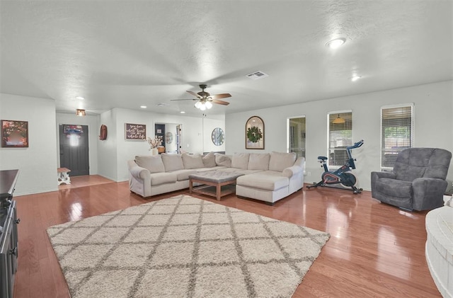 living room featuring wood-type flooring and ceiling fan