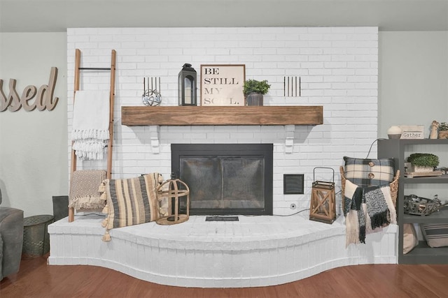 living room featuring hardwood / wood-style flooring and a brick fireplace