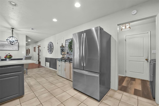 kitchen featuring an inviting chandelier, light hardwood / wood-style flooring, gray cabinets, decorative light fixtures, and stainless steel refrigerator