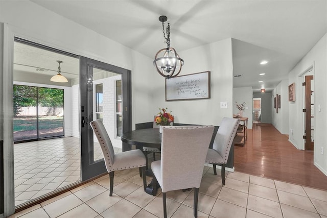 dining area with light hardwood / wood-style flooring and a chandelier