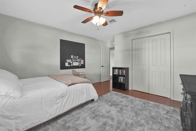 bedroom with ceiling fan, a closet, and dark wood-type flooring