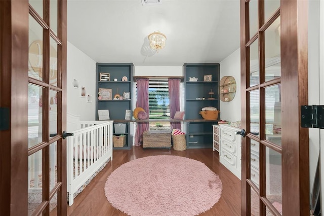 bedroom with a chandelier, french doors, and dark hardwood / wood-style floors